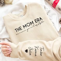 Embrace the warmth of motherhood with our "The mom era we never go out of style" Personalized Sweatshirt. This cute and comfy sweatshirt is more than just clothing; it's a statement of love and devotion, perfect for all the mamas out there. Customize this sweatshirt with the names of your precious kids, making it a unique and meaningful piece that beautifully represents the love you hold for your little ones. Whether you're a new mom or a seasoned one, this sweatshirt celebrates the incredible journey of motherhood. As a thoughtful gift for Mother's Day, birthdays, Christmas, or Thanksgiving, this sweatshirt will become a cherished keepsake. Let the world know that this mama wears her heart on her sleeve with pride. Wrap yourself in comfort and love with this special sweatshirt that honors Casual Family Winter Sweatshirt, Casual Mother's Day Sweatshirt For Family, Casual Winter Sweatshirt For Family Occasions, Casual Sweatshirt For Mother's Day Family Event, Casual Sweatshirt For Mother's Day Family Gathering, Casual Sweatshirt For Family Mother's Day, Casual Sweatshirt For Mother's Day, Cotton Sweatshirt For Fall, Fall Long Sleeve Sweatshirt