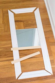 an unfinished mirror frame sitting on top of a wooden floor