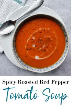 a bowl of tomato soup on a white plate with a spoon and napkin next to it