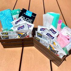 two boxes filled with toilet paper on top of a wooden table next to each other