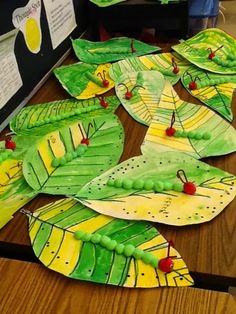 paper plates with leaves and berries on them sitting on top of a wooden table covered in papers