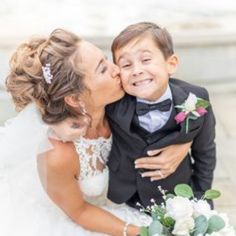 a young boy in a tuxedo kisses his mother's cheek on her wedding day