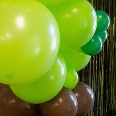 green and brown balloons are in the air