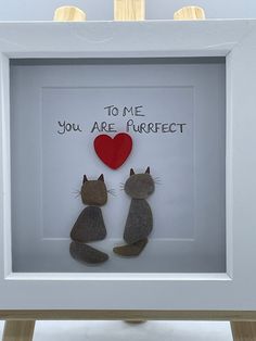 two cats sitting next to each other in a white frame with a red heart on it