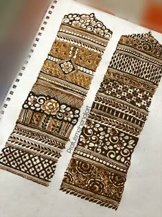 an intricately designed bookmark is shown in gold and white ink on a piece of paper