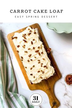 carrot cake loaf sitting on top of a wooden cutting board with pecans around it