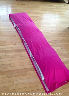 a pink sleeping bag laying on the floor