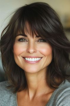 Rounded Face-Framing Layers with Bangs Hairstyle on a smiling woman with brown hair. Face Framing Side Bangs, Round Face With Bangs, Wispy Face Framing Bangs, Face Framing Layers With Bangs, Long Layers With Bangs, Layered Hair With Bangs, Bangs For Round Face, Framing Layers