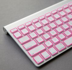 a white and blue keyboard sitting on top of a gray table next to a mouse