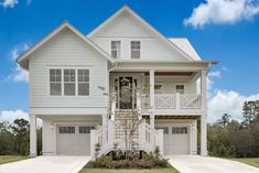 a white two story house with lots of windows and balconies on the second floor