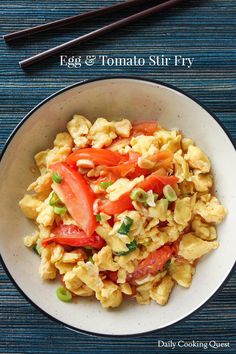 egg and tomato stir fry in a white bowl with chopsticks on the side