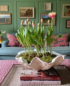 a living room filled with lots of furniture and flowers on top of a coffee table