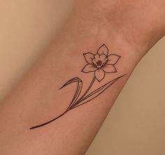 a small flower tattoo on the wrist