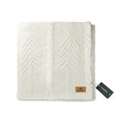 a white knitted blanket with a tag on the front and back of it,