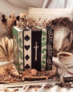 an accordion decorated with playing cards and a crown sits on a table next to other items