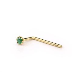 a gold nose ring with a green stone in the shape of a t - bar