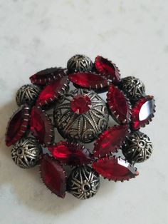 This is a vintage red, glass rhinestone and steel cut brooch. My best guess is that this is from the 1940s. I think it may be older however. It is really a stunning piece. The brooch measures about 2 inches across. Don't forget to stop in at my other Etsy shop... http://www.etsy.com/shop/xtdesigns. Follow me on Twitter at... MyYiayiaHadThat@MyYiayiaHadThat. If you have a wish list or are looking for something specific, please ask. I may have exactly what you are looking for. As always please con Vintage Red Brooches For Formal Occasions, Vintage Red Brooches For Party, Antique Red Brooches As A Gift, Vintage Red Wedding Brooches, Vintage Red Jewelry With Rhinestones, Antique Red Wedding Brooch, Vintage Red Rhinestone Jewelry, Retro Red Brooch Jewelry, Red Retro Brooch Jewelry