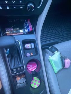 the interior of a car with various items in it's center console and cup holder