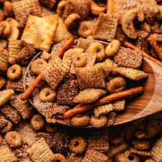 a wooden spoon filled with cheerios on top of a pile of other cereals