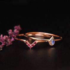 "Moonstone and Ruby, a phenomenal combination!! These rings can be personalized with other birthstones as well. Please convo for details and prices. Can be purchased as a set or individually. Please select from 'Style' dropdown PEAR MOONSTONE RING: * Stone Wt. : 0.21 Cts (approx.) * Shape/Cut : Pear/Cabochon * Gold - 14kt, solid rose gold Note: Since it is a natural gemstone, the blue flashes will vary from the pictures. RUBY V BAND: * Stone : Natural Ruby * Stone Weigt : 0.10 Cts (approx.) * St Wedding Moonstone Ring With Gemstone Accents In 14k Gold, Rose Gold Stackable Moonstone Ring For Anniversary, Stackable Rose Gold Moonstone Ring For Anniversary, Ruby Wedding Ring Set, Rainbow Moonstone Engagement Ring, Ruby Wedding Ring, Ruby Wedding Rings, Ruby Wedding, Moonstone Engagement