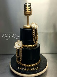 a black and gold cake with a microphone on top