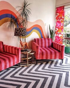 a living room with two red chairs and a zebra rug