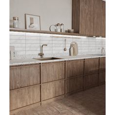 a kitchen with wooden cabinets and white counter tops, along with a gold faucet