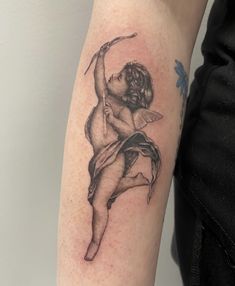 a woman with a tattoo on her arm holding a bow and arrow in one hand