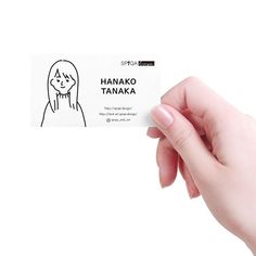 a hand holding a business card with a drawing of a girl