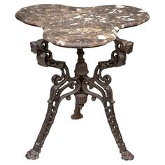 an ornately decorated table with marble top and iron legs, on white background photo