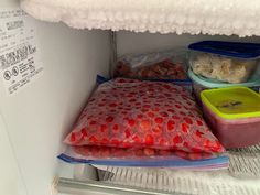 an open refrigerator filled with lots of food and containers on top of the freezer