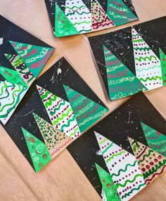 paper christmas trees are arranged on black cards