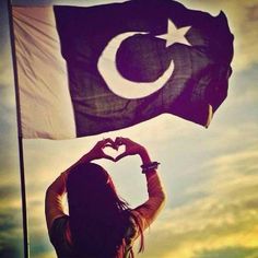 a woman holding up a flag in the shape of a heart with her hands,