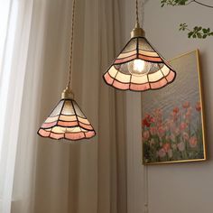 two stained glass lamps hanging from a ceiling