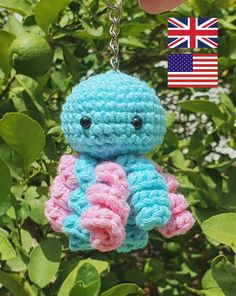 a small crocheted stuffed animal hanging from a keychain with an american flag in the background