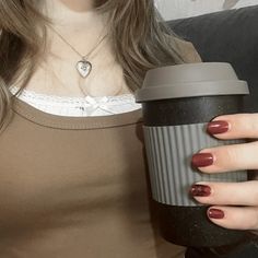 a woman holding a cup of coffee in her right hand