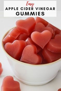 an apple cider vinegar gummies in a white bowl with hearts on the side