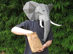 a man holding a brown paper bag with an elephant on it's head and wearing a mask