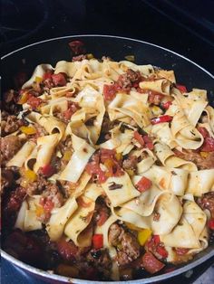 a pan filled with pasta and meat on top of a stove