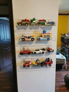 there are many toy trucks on the shelves in this room and one is painted white