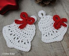 two crocheted white doily with red bows on them next to a christmas ornament