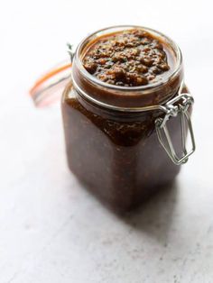 a jar filled with brown sauce sitting on top of a table