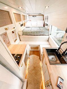 the interior of a tiny house with a bed, sink and kitchenette in it