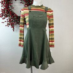 This Olive Corduroy Jumper Set Is Fun And Playful With The Bright Multi Color Matching Top. This Is A Great Back To School Look For Sure She Will Look Comfy And Right In Style. Olive Corduroy Jumper With Front Pocket On Bib, Self Ruffle Hem And Fun Overall Shoulder Straps Two Piece Corduroy Jumper Set Set Includes - One Jumper And One Top Bright Multi Striped Knit Top With Lettuce Edged Mock Neck Pullover, And Lettuce Edged Cuff Jumper - 100% Cotton, Top - Polyester, Rayon, Spandex Machine Washa Fitted Casual Pinafore Dress For Fall, Fitted Cotton Pinafore Dress For Fall, Casual Corduroy Pinafore Dress For Fall, Casual Cotton Pinafore Dress With Ruffles, Casual Cotton Pinafore Dress For Fall, Fitted Cotton Pinafore Dress Casual Style, Fitted Cotton Casual Pinafore Dress, Casual Fall School Dresses, Casual Winter School Dress