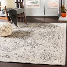 a living room area with a rug, chair and window