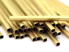 several gold colored metal tubes stacked on top of each other, all lined up and ready to be used