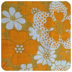 an orange and white flowered fabric with polka dot dots on it's edges