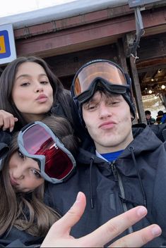 three people wearing ski goggles are posing for the camera