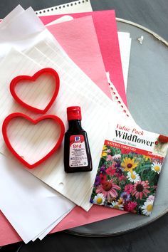 some crafting supplies are laying out on a table with paper and glue to make heart shaped cards