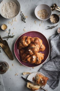 croissants and other food items on a table with utensils in bowls